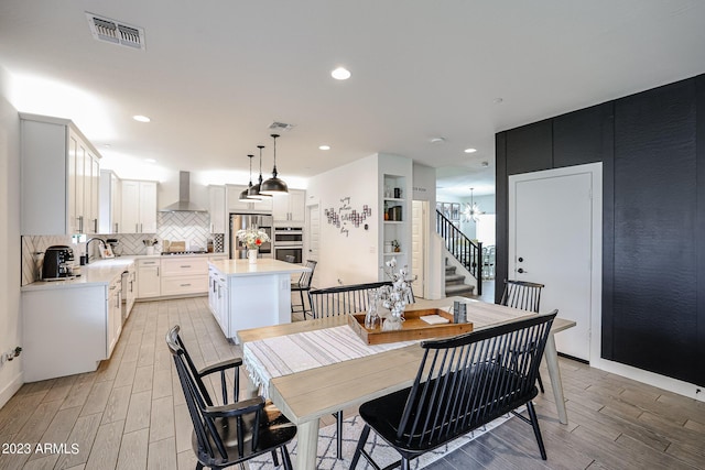 dining area featuring light wood-style floors, a notable chandelier, recessed lighting, and visible vents