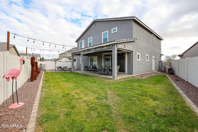 rear view of property with a lawn, a fenced backyard, and a patio area