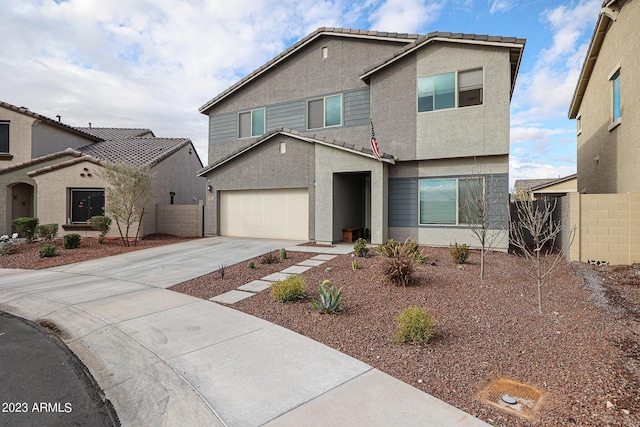 traditional-style home featuring an attached garage, fence, driveway, and stucco siding