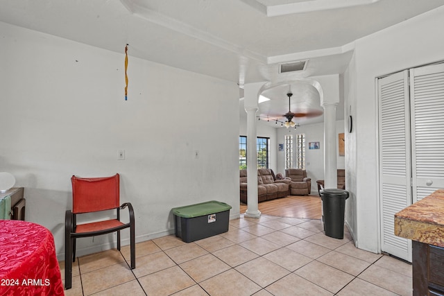 interior space with decorative columns and a raised ceiling