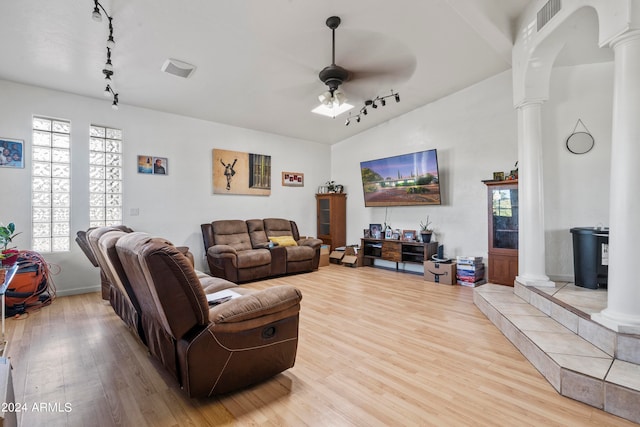 living room with ceiling fan, wood-type flooring, vaulted ceiling, and ornate columns