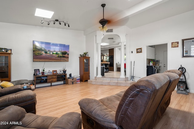 living room with ceiling fan, hardwood / wood-style floors, and ornate columns