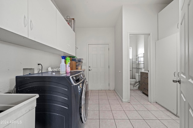 laundry area with cabinets, independent washer and dryer, sink, and light tile patterned flooring