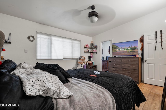 bedroom with ceiling fan, vaulted ceiling, and light hardwood / wood-style floors