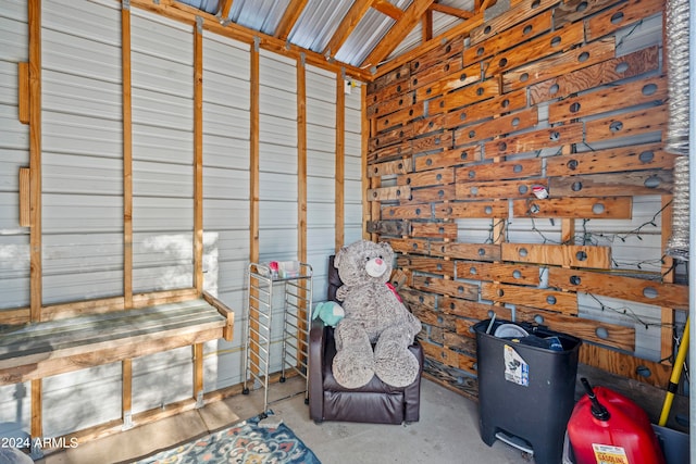 sitting room featuring lofted ceiling and concrete flooring