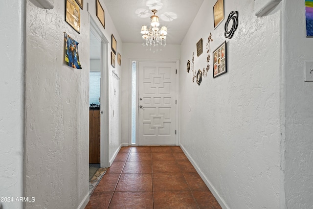 entryway featuring a chandelier and dark tile patterned floors