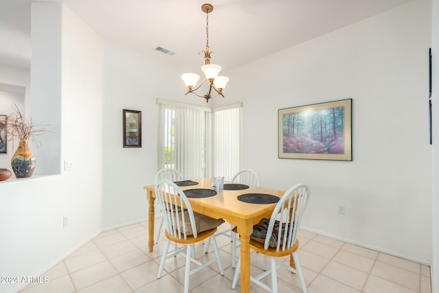 tiled dining room featuring an inviting chandelier