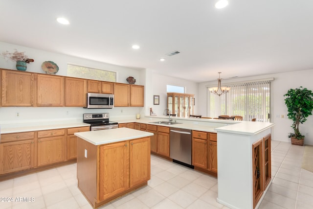 kitchen with appliances with stainless steel finishes, plenty of natural light, and a kitchen island