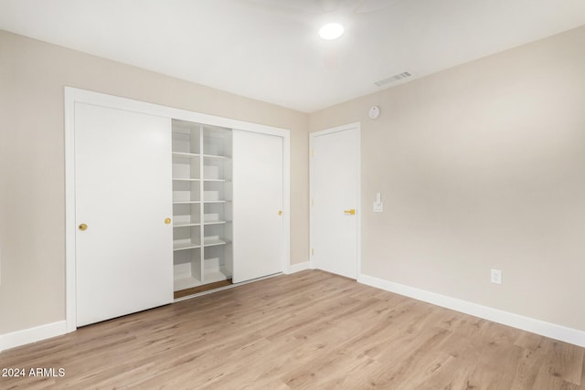 unfurnished bedroom featuring a closet and light wood-type flooring