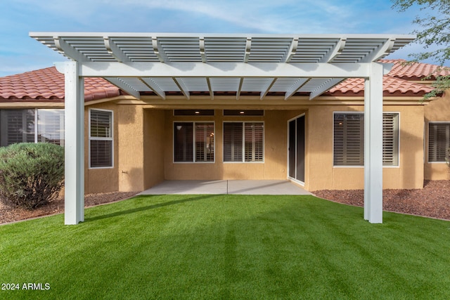 back of property featuring a pergola, a patio area, and a lawn