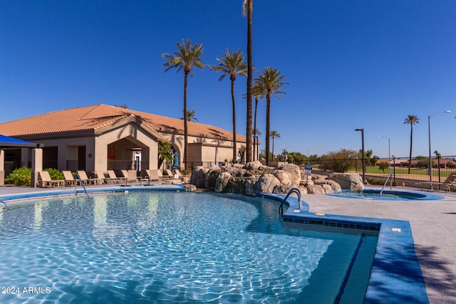 view of swimming pool with a hot tub and a patio area