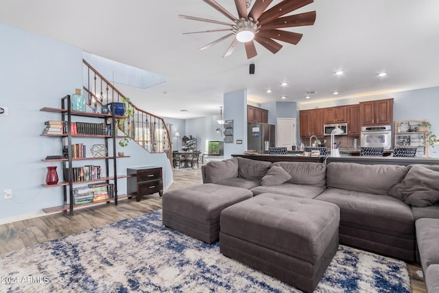 living room featuring ceiling fan and light hardwood / wood-style flooring