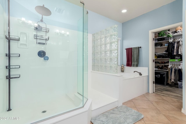 bathroom with separate shower and tub and tile patterned floors