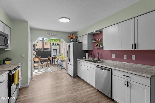 6289 E Duchess Dr, Prescott Valley, AZ 86314 - kitchen featuring appliances with stainless steel finishes, a sink, open shelves, light countertops, and light wood-style floors