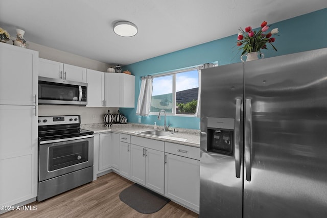 6289 E Duchess Dr, Prescott Valley, AZ 86314 - kitchen featuring appliances with stainless steel finishes, a sink, white cabinets, light countertops, and light wood finished floors