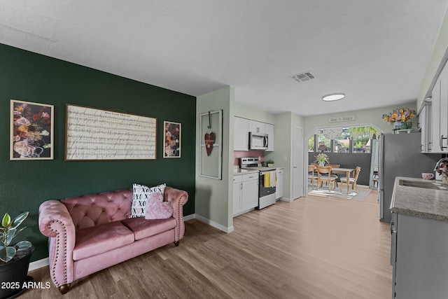 6289 E Duchess Dr, Prescott Valley, AZ 86314 - living room featuring light wood-style flooring and baseboards