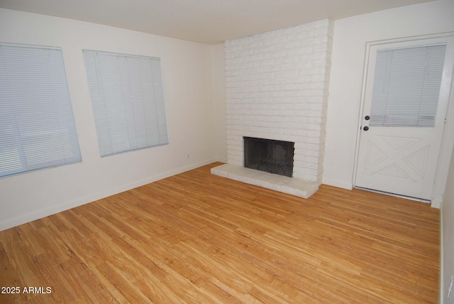 2015 E Southern Ave Unit 23, Tempe, AZ 85282 - unfurnished living room with a brick fireplace and light wood-style flooring