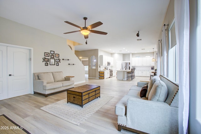 living room with plenty of natural light, ceiling fan, recessed lighting, and light wood-type flooring