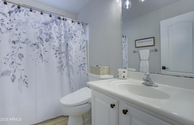 bathroom featuring a shower with shower curtain, toilet, and vanity
