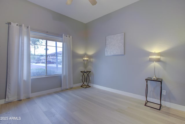 unfurnished room with ceiling fan, baseboards, and wood finished floors