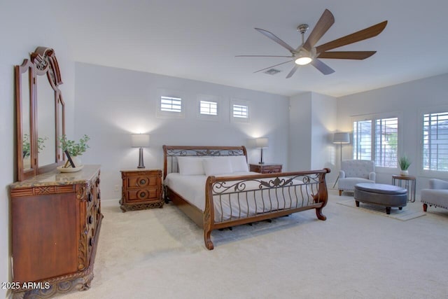 bedroom featuring light colored carpet, baseboards, and a ceiling fan