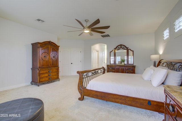 carpeted bedroom featuring visible vents, arched walkways, and multiple windows