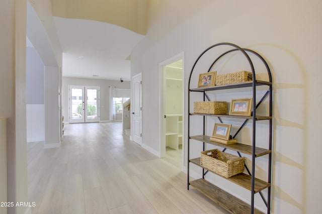 hall with light wood finished floors and baseboards