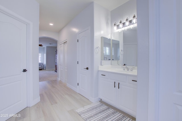 bathroom with recessed lighting, wood finished floors, vanity, and ensuite bathroom