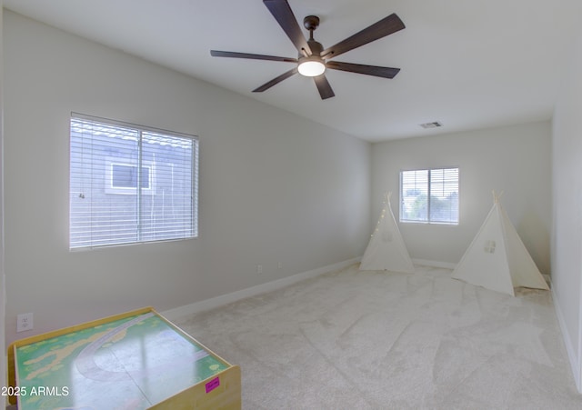 game room featuring light carpet, a ceiling fan, visible vents, and baseboards