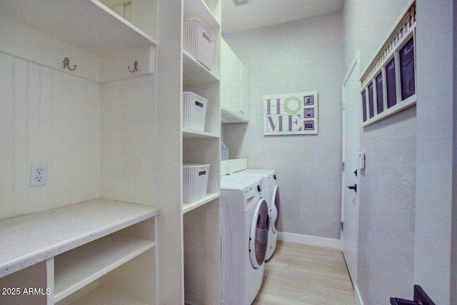 washroom with light wood finished floors, baseboards, and separate washer and dryer
