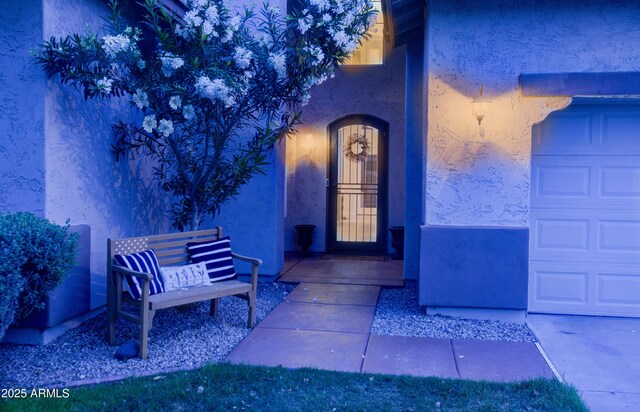 entrance to property featuring stucco siding and a garage