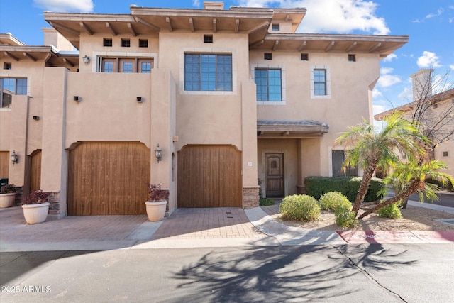 view of front of property with a garage, decorative driveway, and stucco siding