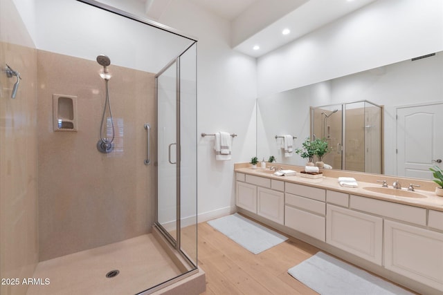 bathroom featuring an enclosed shower, vanity, and hardwood / wood-style flooring