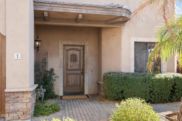 doorway to property featuring stucco siding