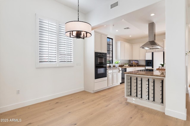 kitchen with decorative light fixtures, white cabinets, island exhaust hood, stone countertops, and black appliances