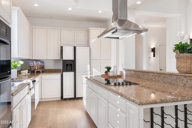 kitchen with paneled built in refrigerator, island range hood, black electric stovetop, a spacious island, and white cabinets