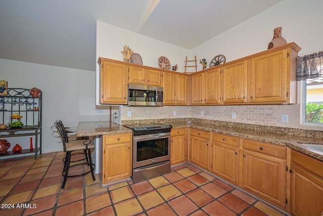 kitchen featuring a breakfast bar area, kitchen peninsula, tasteful backsplash, and stainless steel appliances