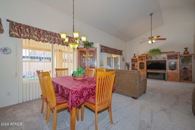 dining room featuring ceiling fan with notable chandelier, lofted ceiling, and light carpet