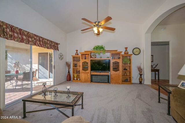 carpeted living room with ceiling fan and high vaulted ceiling