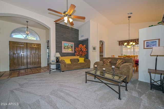 living room with ceiling fan with notable chandelier, carpet floors, and high vaulted ceiling