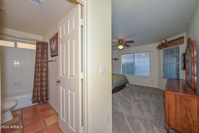 bathroom with a wealth of natural light, ceiling fan, tile patterned floors, toilet, and shower / bath combo with shower curtain