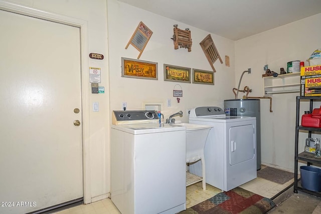 clothes washing area featuring electric water heater and independent washer and dryer