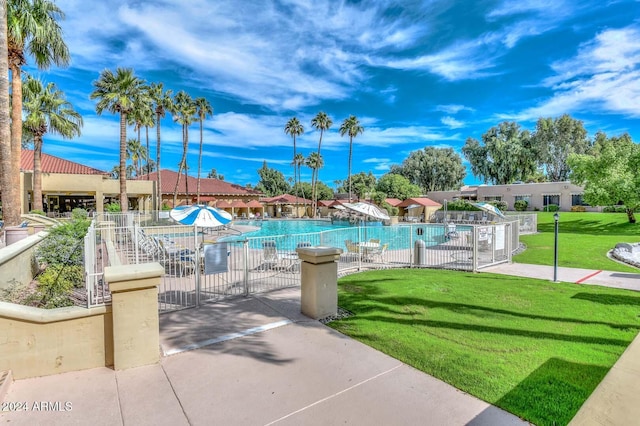 view of swimming pool featuring a lawn and a patio