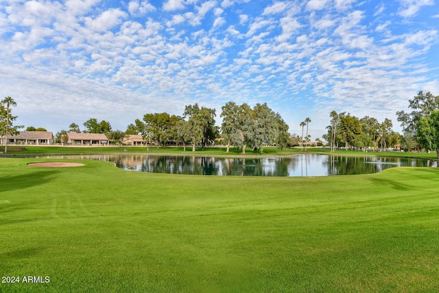 view of property's community featuring a lawn and a water view