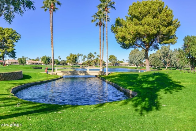 surrounding community with a lawn and a water view