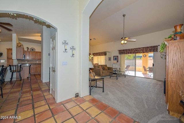 living room featuring ceiling fan, lofted ceiling, and light carpet