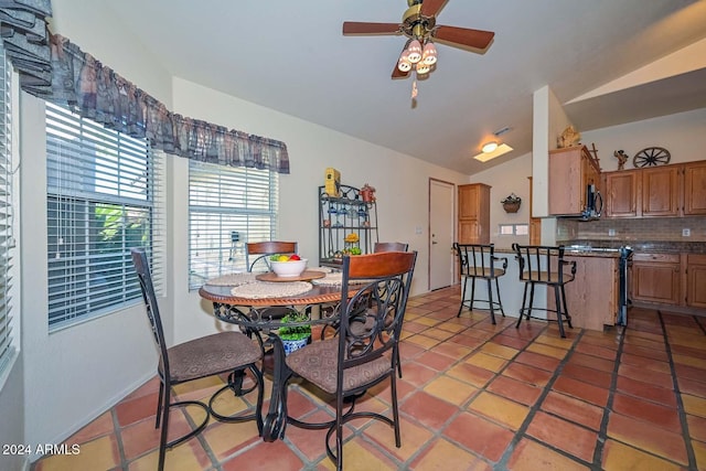 dining room featuring ceiling fan, light tile patterned floors, and vaulted ceiling