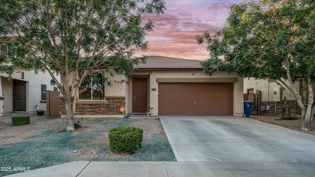 11742 W Chase Ln, Avondale, AZ 85323 - view of front of home featuring stucco siding, concrete driveway, a garage, stone siding, and a tile roof