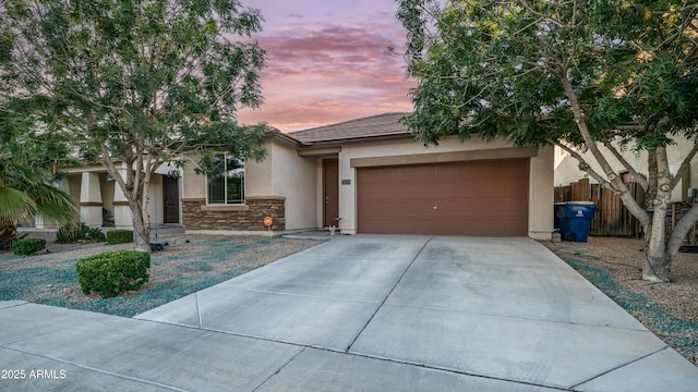 11742 W Chase Ln, Avondale, AZ 85323 - view of front facade with stucco siding, concrete driveway, an attached garage, and stone siding