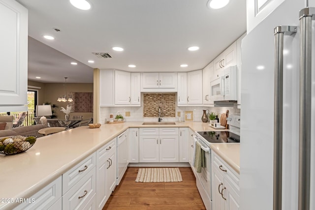 10330 W Thunderbird Blvd Unit A301, Sun City, AZ 85351 - kitchen with white appliances, a sink, light wood-type flooring, backsplash, and light countertops